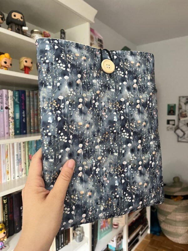 Funda literaria con exterior impermable. con Flores sobre fondo azul que asemeja una venta con agua tras la lluvia.